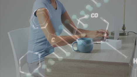 animación de estructuras químicas y cadena de adn sobre una mujer biracial usando una computadora portátil