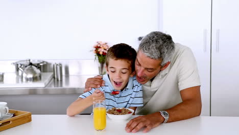 Padre-Burlándose-De-Su-Hijo-Mientras-Desayuna