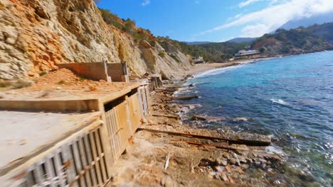 fpv drone flying along the spanish coast and through the balcony of a boathouse