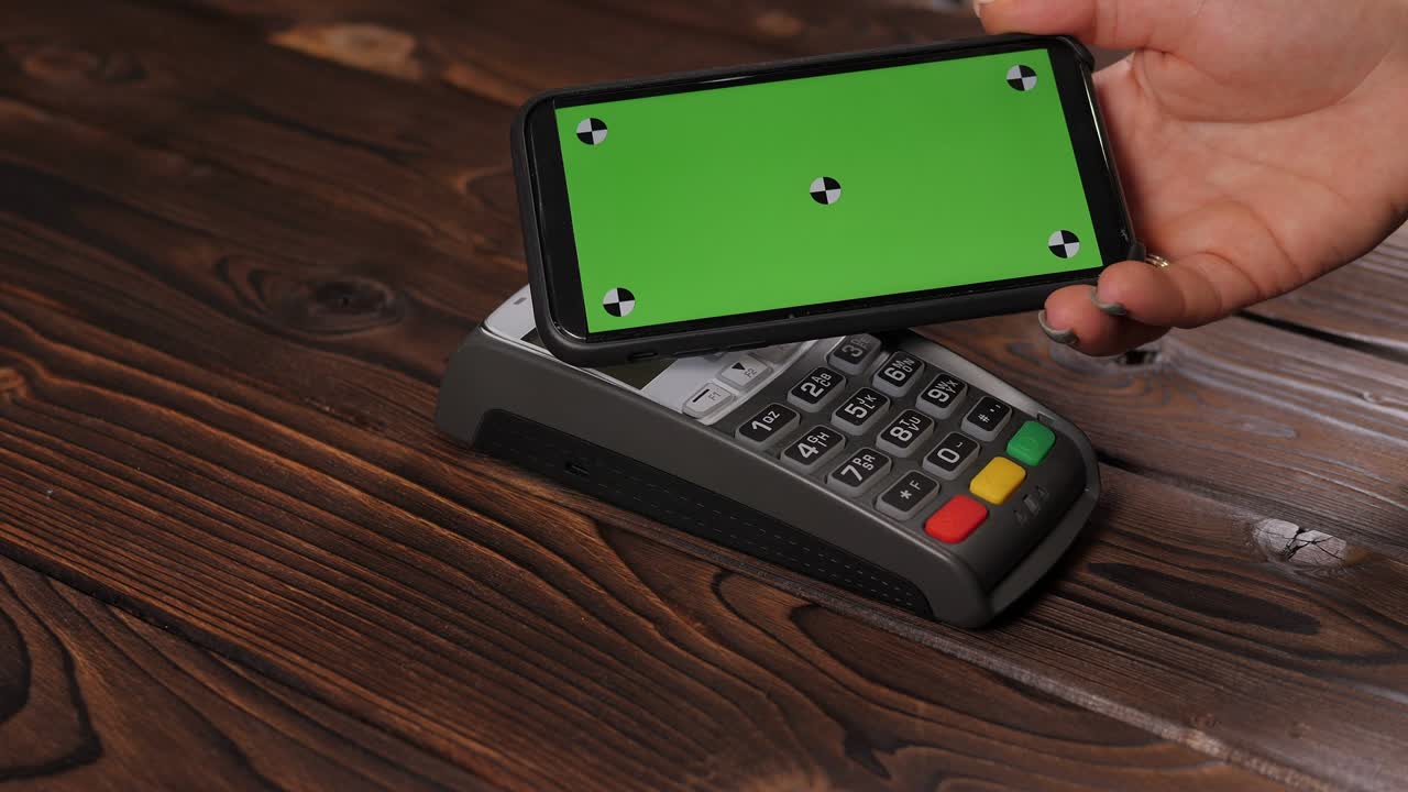 Close-up a smartphone with green screen template with an NFC payment technology.