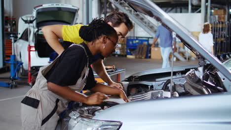 repair shop workers fix car with wrench