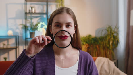 Woman-holding-magnifier-glass-on-teeth,-happy-expression,-showing-funny-smiling-silly-face-mouth