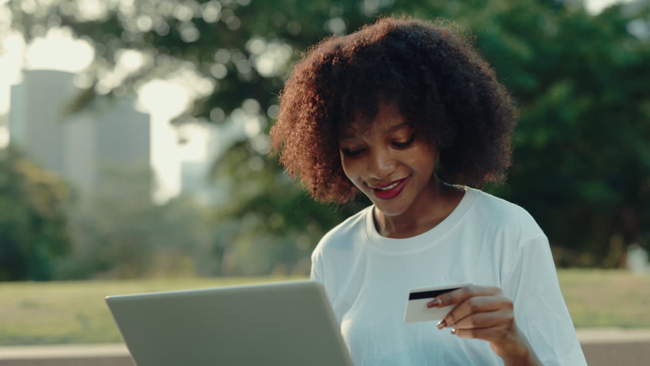 Woman shopping online in a park