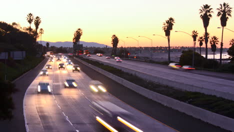los coches de lapso de tiempo viajan por una autopista al atardecer o al atardecer