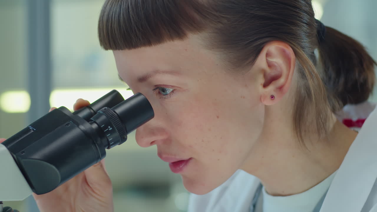 Woman Working with Microscope in Lab