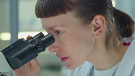 woman working with microscope in lab