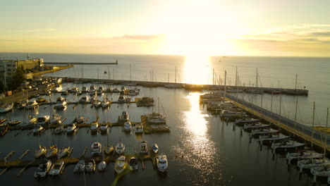 toma aérea de la hermosa puesta de sol sobre el puerto oceánico con veleros atracados