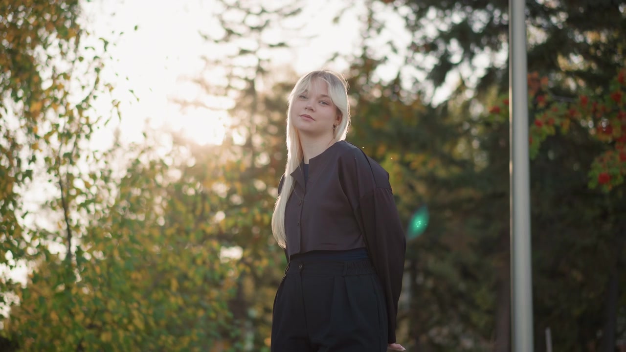 Young Blonde Woman Standing Outdoors in Autumn Park