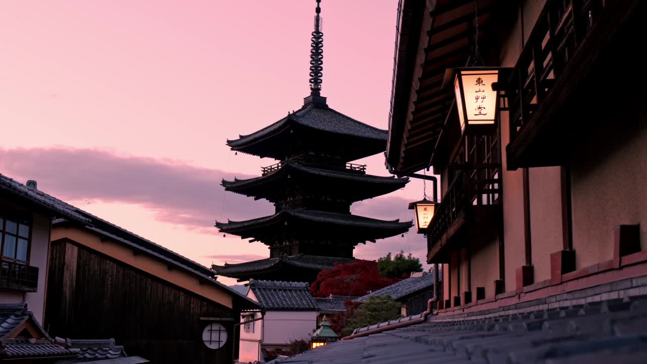 The Yasaka Pagoda in Kyoto stands beautifully illuminated by the warm hues of the setting sun, casting its tranquil silhouette against the sky.