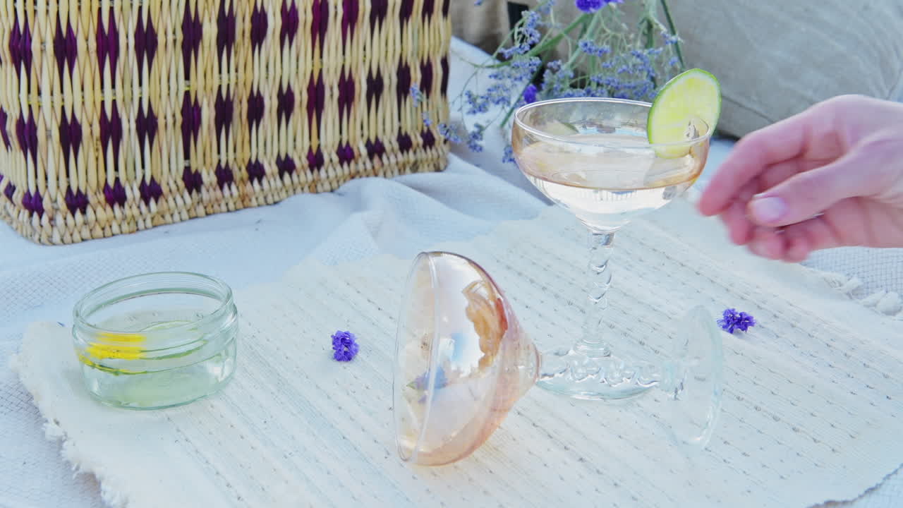 Luxury refreshing cocktail in fancy stylish glasses in romantic outdoor picnic for al fresco dining on picnic blanket - close up