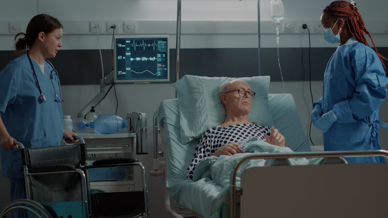 Nurse bringing wheelchair to patient in hospital ward bed