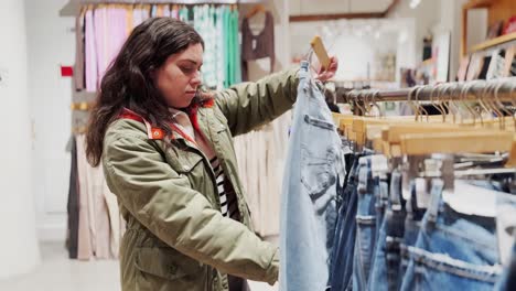 young woman browsing jeans in a fashion boutique