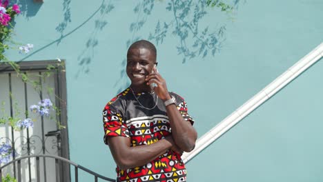 black man having phone call near wall