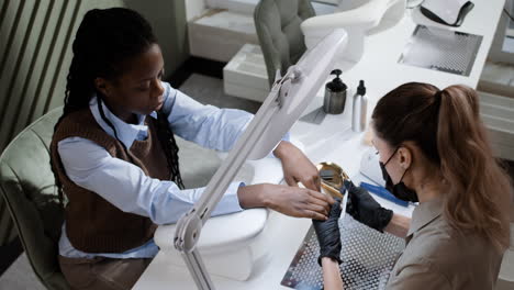 woman receiving a manicure at a nail salon