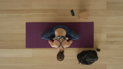 overhead view flexible yoga woman practicing lotus forward bend pose enjoying healthy lifestyle exercising in fitness studio training on exercise mat