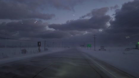 Conduciendo-Por-Una-Carretera-En-Medio-De-Una-Fuerte-Tormenta-De-Nieve-Con-Un-Dramático-Paisaje-Nuboso-Al-Frente