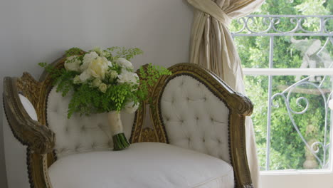 wedding bouquet with white and green flowers on an antique chair with ornaments