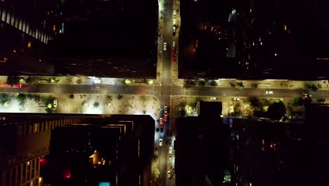 aerial view birdseye over illuminated santiago, chile urban traffic moving through high rise city streets