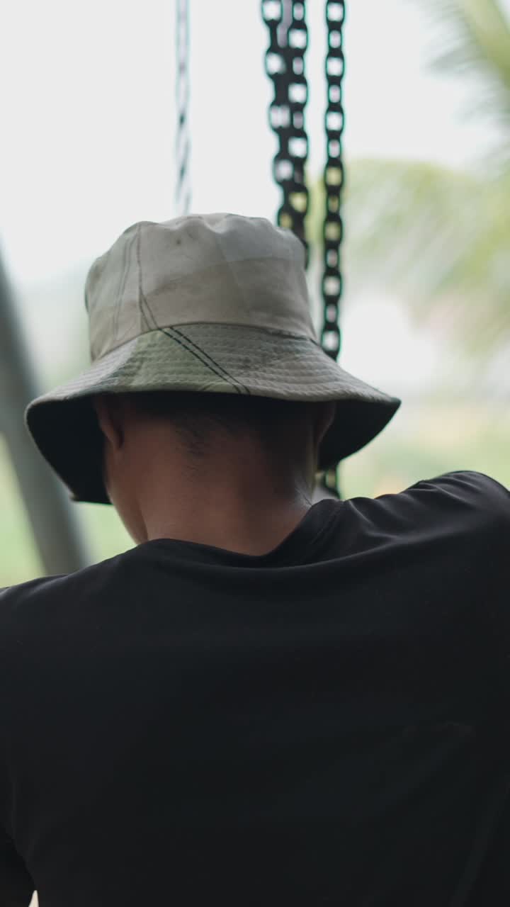 Person wearing a hat next to a chain