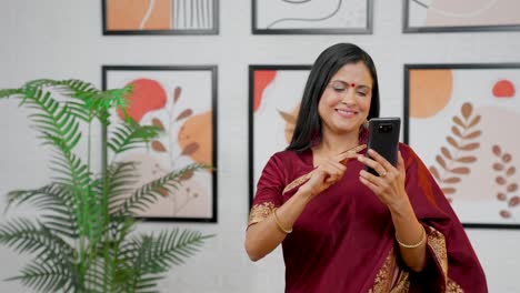Mujer-India-Emocionada-Desplazándose-Por-Teléfono