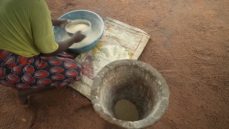 woman sifting cassava flour. over the shoulder