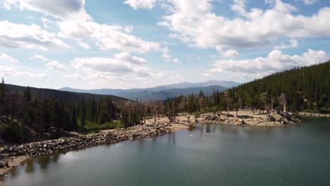 ascending from glacier lake to view the colorado rocky mountains, aerial