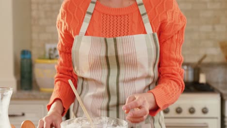 woman wearing apron breaking an egg into the mixture in the kitchen 4k 4k