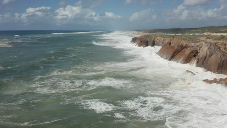 flying low over heavy white waves on a restless sea