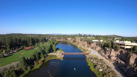 Aerial-view-of-a-vibrant-town-with-river-and-mountains