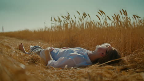 woman lying in a golden wheat field
