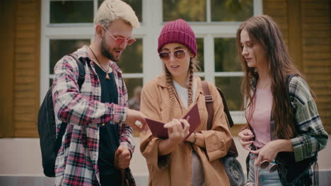 amigos leyendo un libro frente al edificio