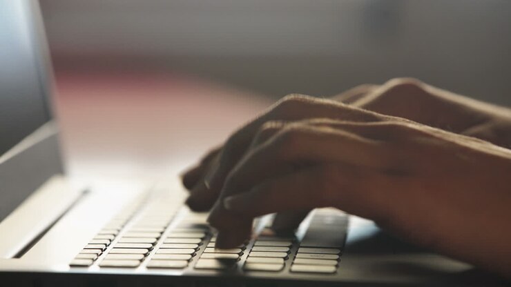 Hände tippen auf einer Laptoptastatur