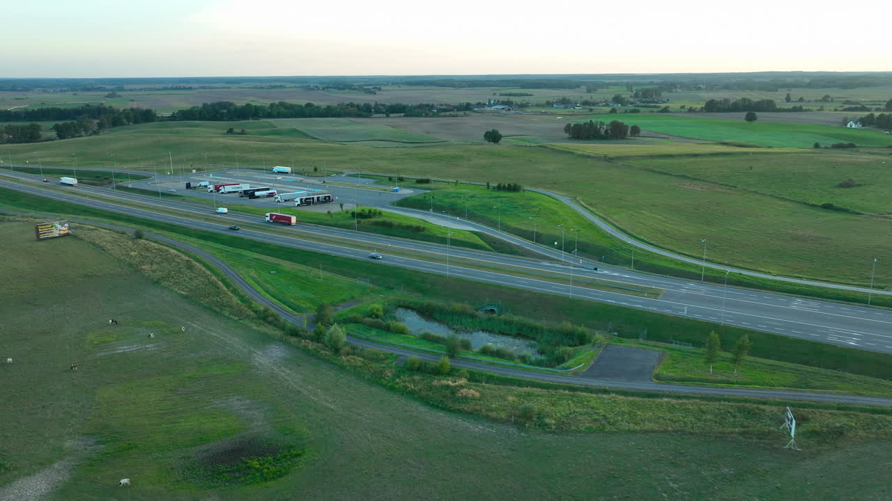 아침 일찍 또는 오후 늦은 시간 동안 넓고 푸른 시골 풍경에 맞춰 휴식 공간과 차량이 있는 고속도로의 공중 광경