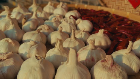 fresh garlic bulbs and dried chili peppers on a market table in wuzhen, china