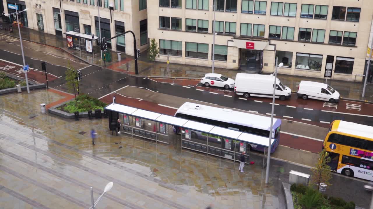 Time lapse of a busy bus stop on a rainy day