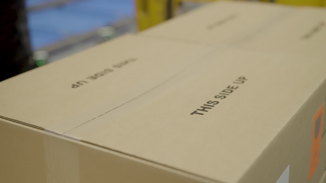 Cardboard boxes labeled "This Side Up" arranged in rows, symbolizing shipping and packaging care