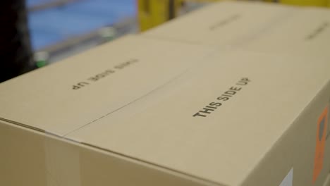 cardboard boxes labeled "this side up" arranged in rows, symbolizing shipping and packaging care