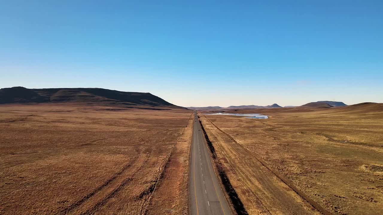 camino recto de alquitrán a través de los paisajes secos de karoo y las serenas tierras de cultivo - sudáfrica