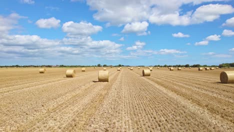 Über-Der-Landschaft-Von-Lincolnshire-Fängt-Die-Kamera-Einen-Beeindruckenden-Anblick-Ein:-Windturbinen-Drehen-Sich-Anmutig-Inmitten-Eines-Frisch-Abgeernteten-Feldes,-Akzentuiert-Durch-Goldene-Heuballen