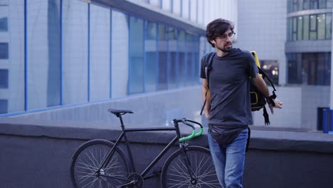 courier puts on shoulders his delivery backpack and ready to go