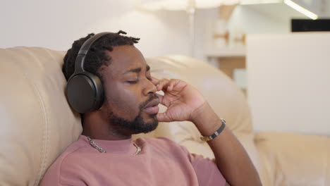 man relaxing on couch with headphones