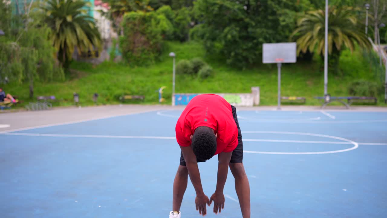 Man Stretching on Basketball Court