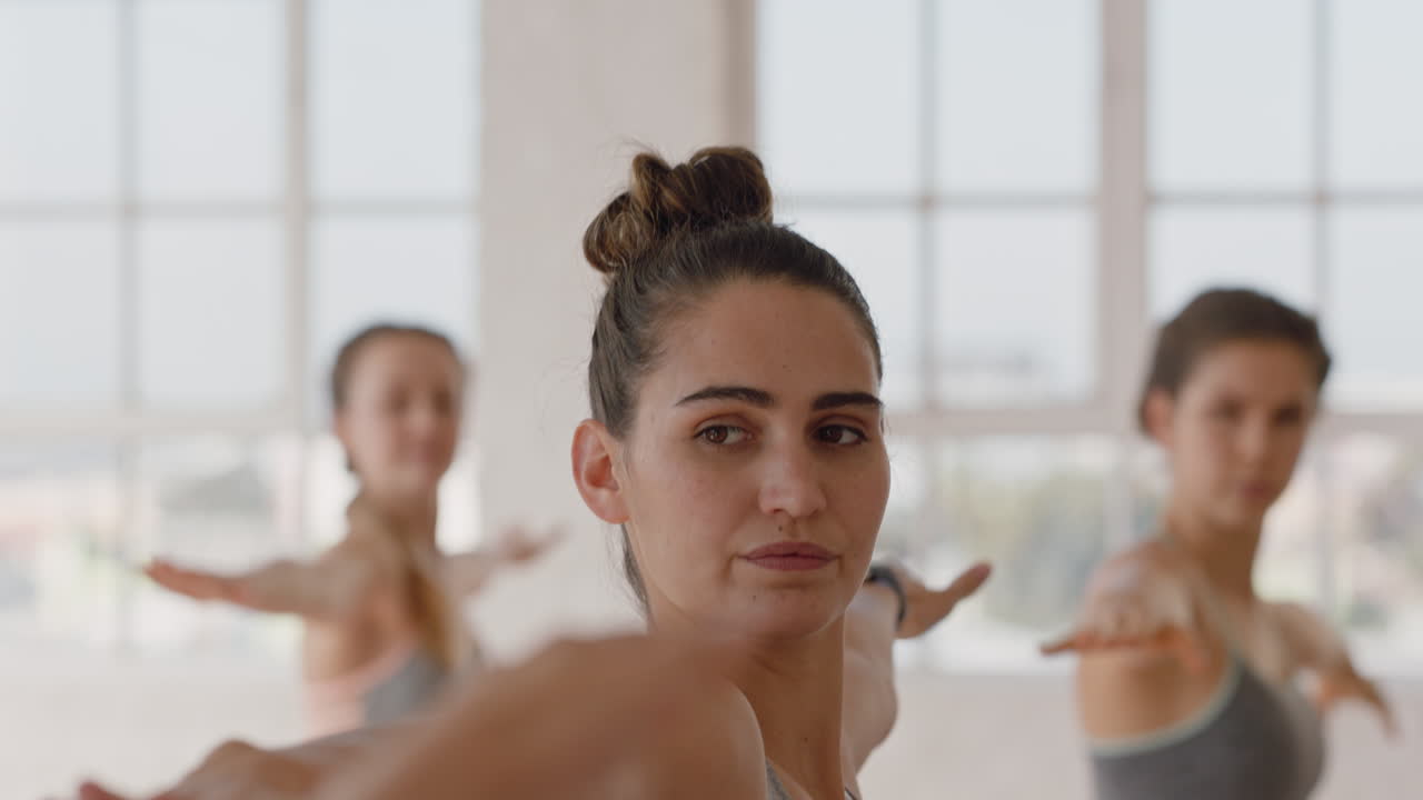 clase de yoga hermosa mujer caucásica practicando pose guerrera instructor de fitness enseñando a un grupo de mujeres multiétnicas práctica de meditación saludable en un estudio de entrenamiento