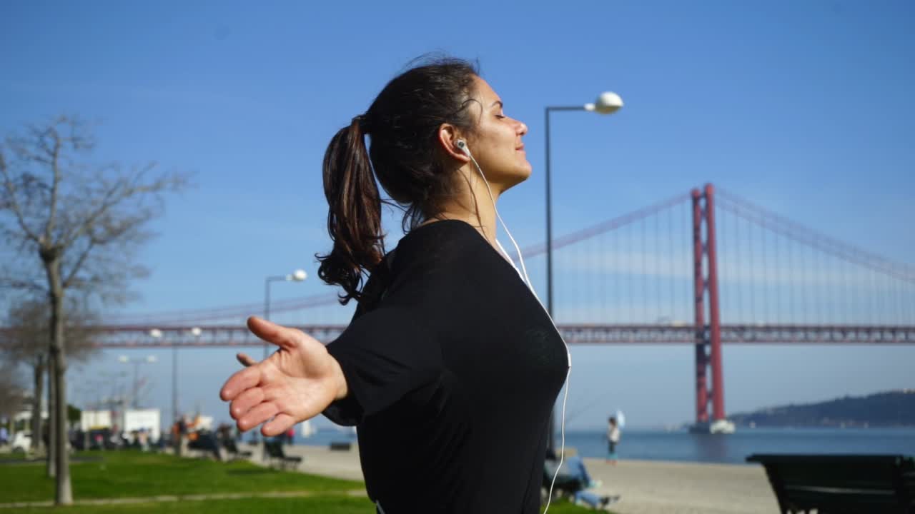 hermosa chica deportiva meditando con los brazos abiertos en el parque