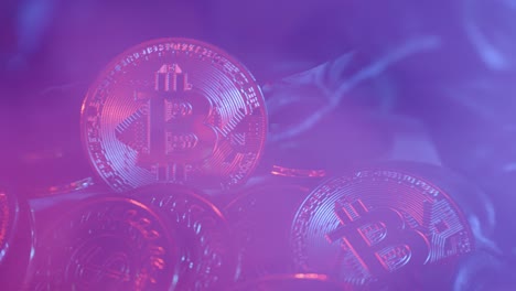 slow establishing shot of smoke blowing over golden bitcoin coins