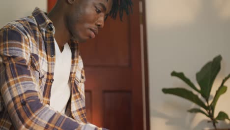 Profile-of-african-american-man-working-precisely-in-workshop