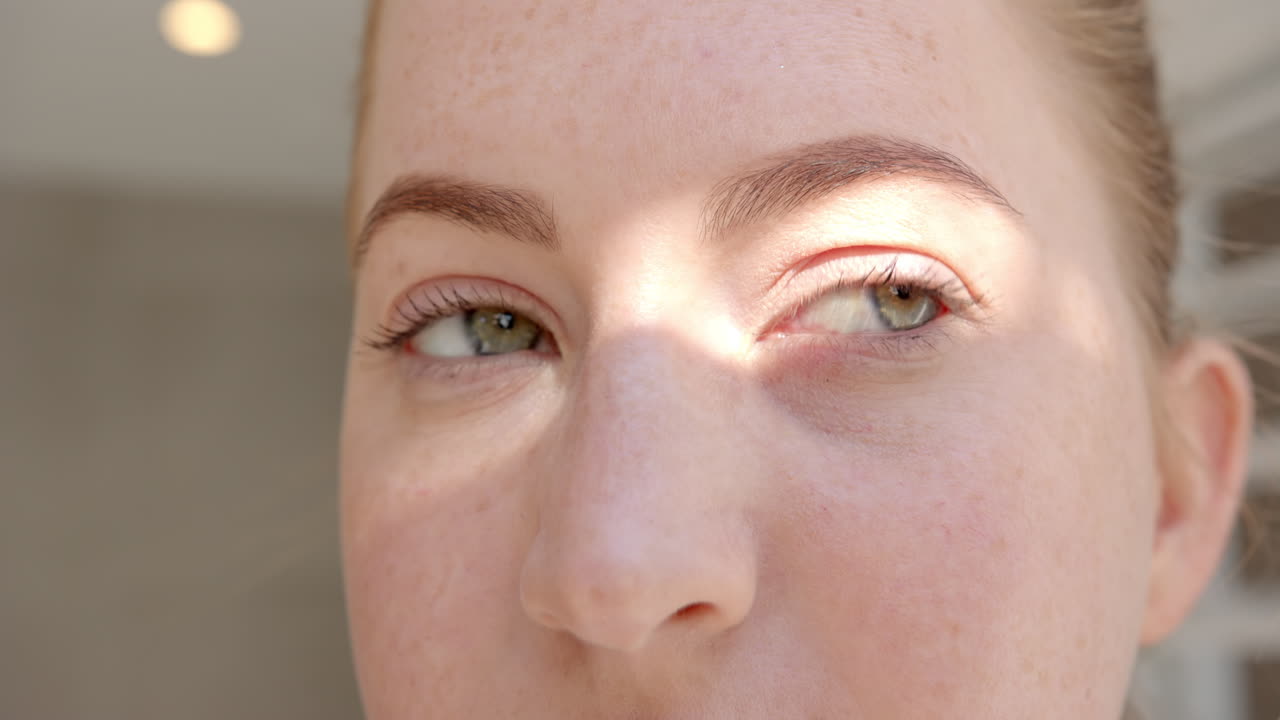 Close-up of woman's face with sunlight highlighting her green eyes