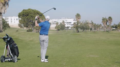 Vista-Trasera-En-Tiempo-Real-Tiro-Varón-Caucásico-Balanceándose-En-Campo-De-Golf-En-Almería,-España