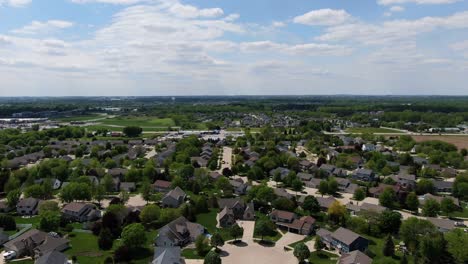 wide aerial backwards pan of neighborhood in wisconsin, usa on a cloudy day