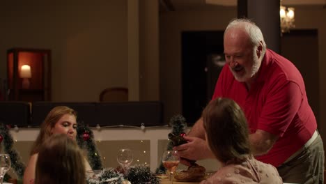 Man Pours Wine for Guests at a Festive Christmas Dinner Gathering